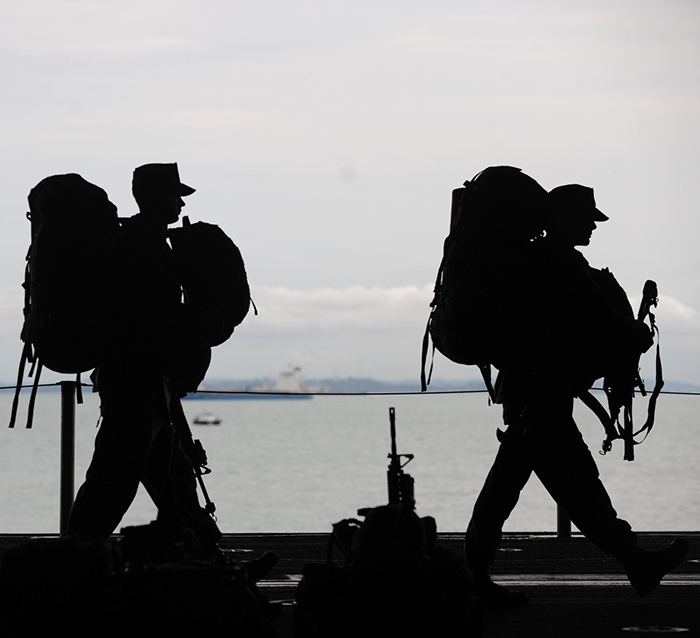 silhouettes of military walking in full gear